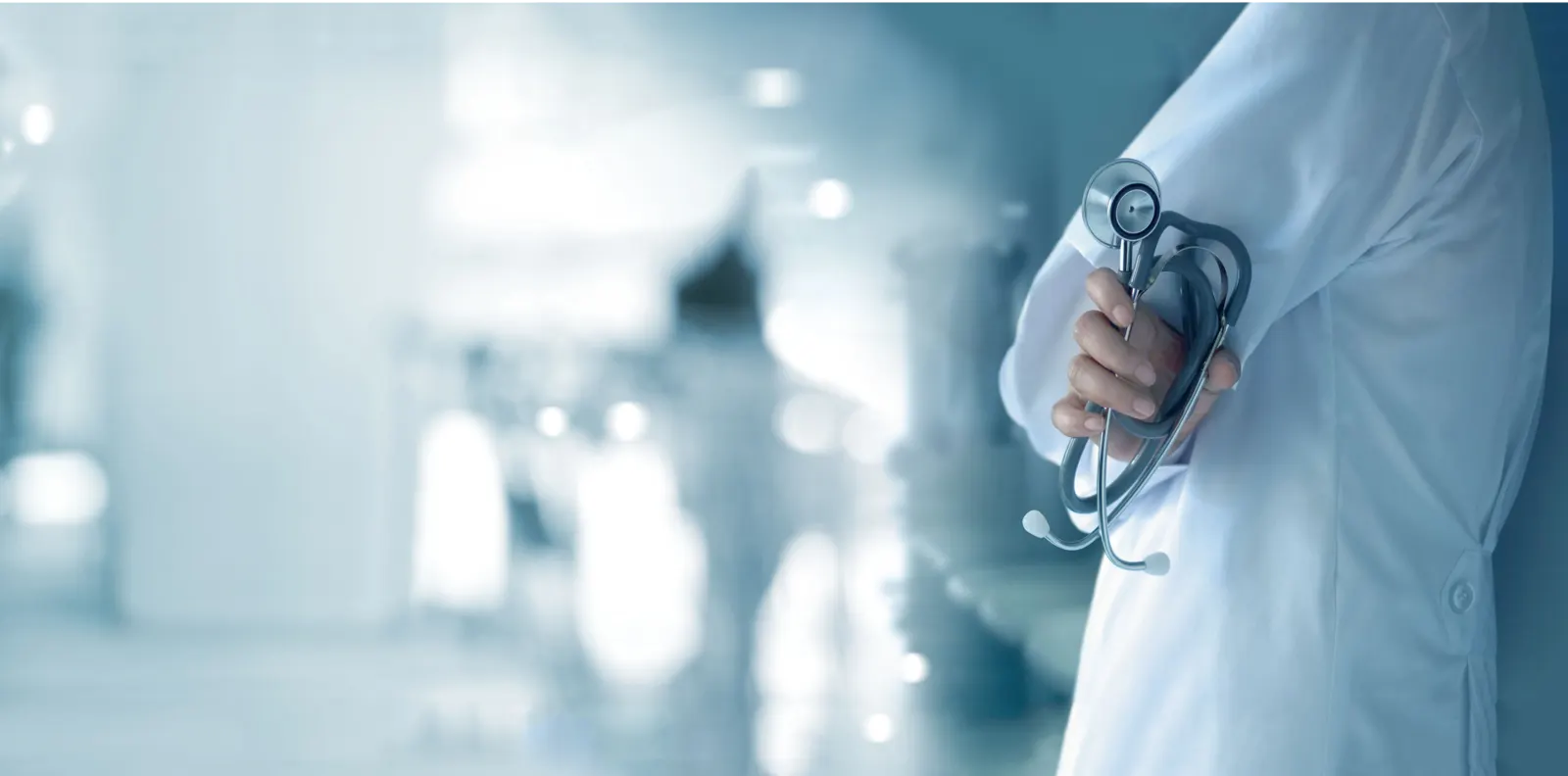 Doctor with stethoscope in a bright hospital corridor